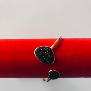 Brazalete Rígido Dorado con Detalles Asimétricos en Pedrería Negra